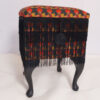reupholstered furniture a sewing box with tassels around it and black legs white background