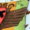 cushion with heart with wings on cushion corner