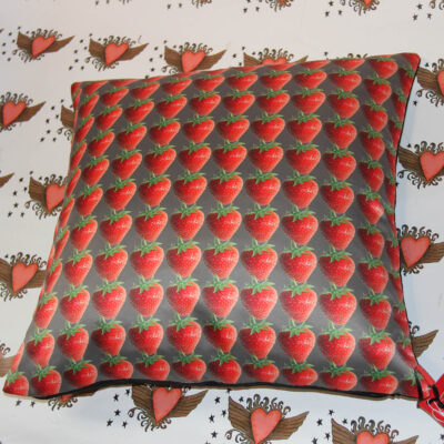 cushion cover with strawberries on charcoal background, background has heart design