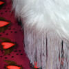 left hand side of a white faux fur footstool sitting on graffiti heart wallpaper