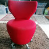Red swivel chair before upholstery sitting in work room
